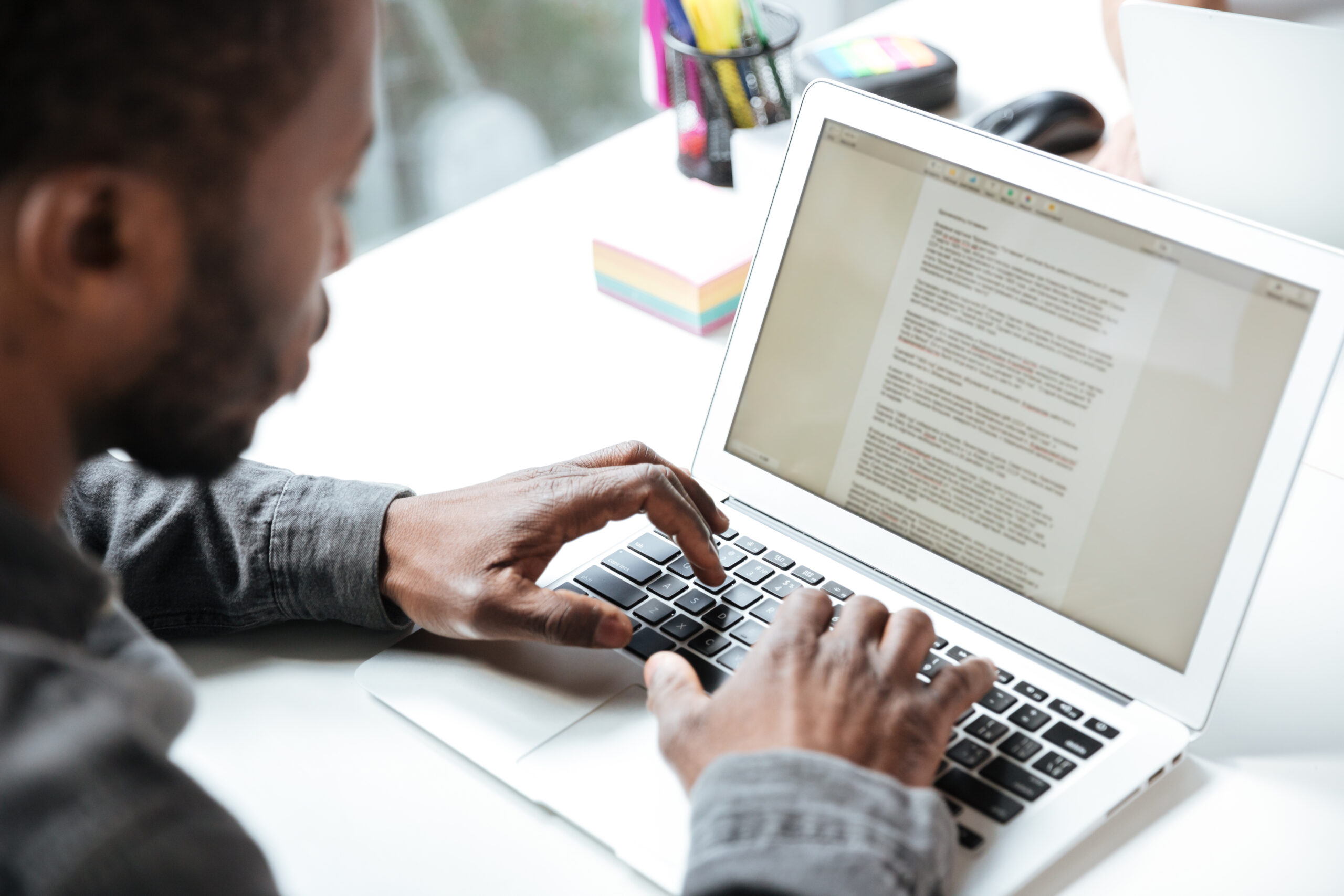 Home cropped photo of serious young man sitting in office coworking